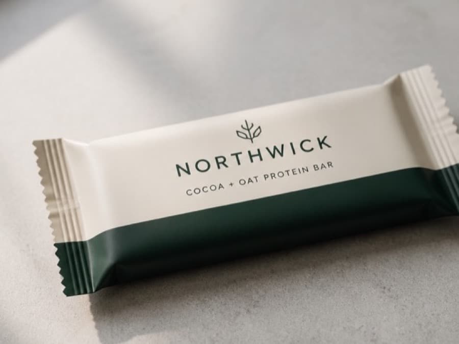 A protein bar in plain packaging photographed on a kitchen counter